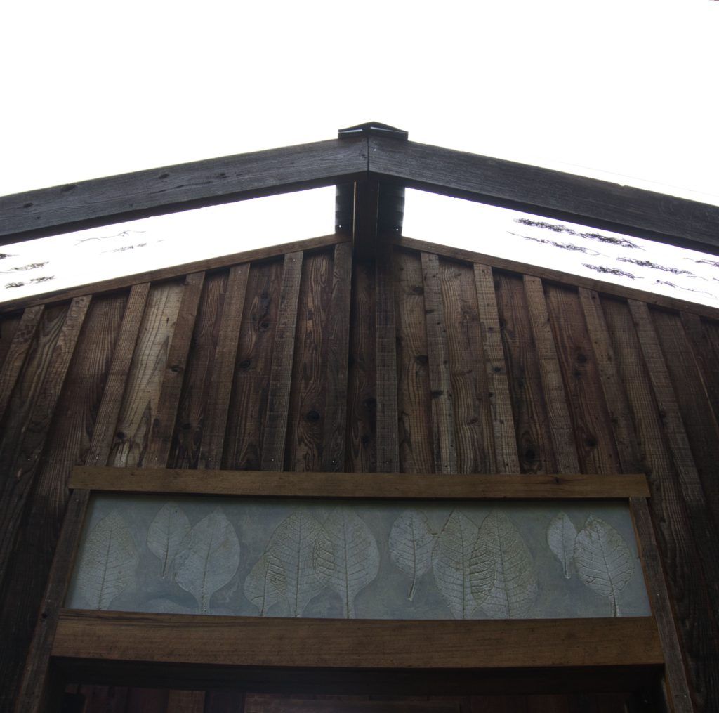 outdoor concrete panel over house entryway with tobacco leaf imprints 