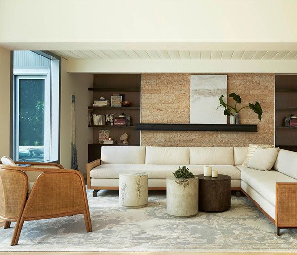Modern, warm-toned living room with three round concrete coffee tables with botanical designs