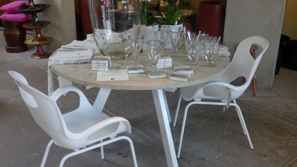 Round white concrete dining table with steel base at The Gardener in Berkeley, CA