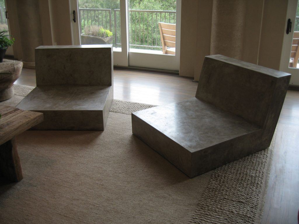 Two large, light brown lowlying Concrete loveseats in living room environment