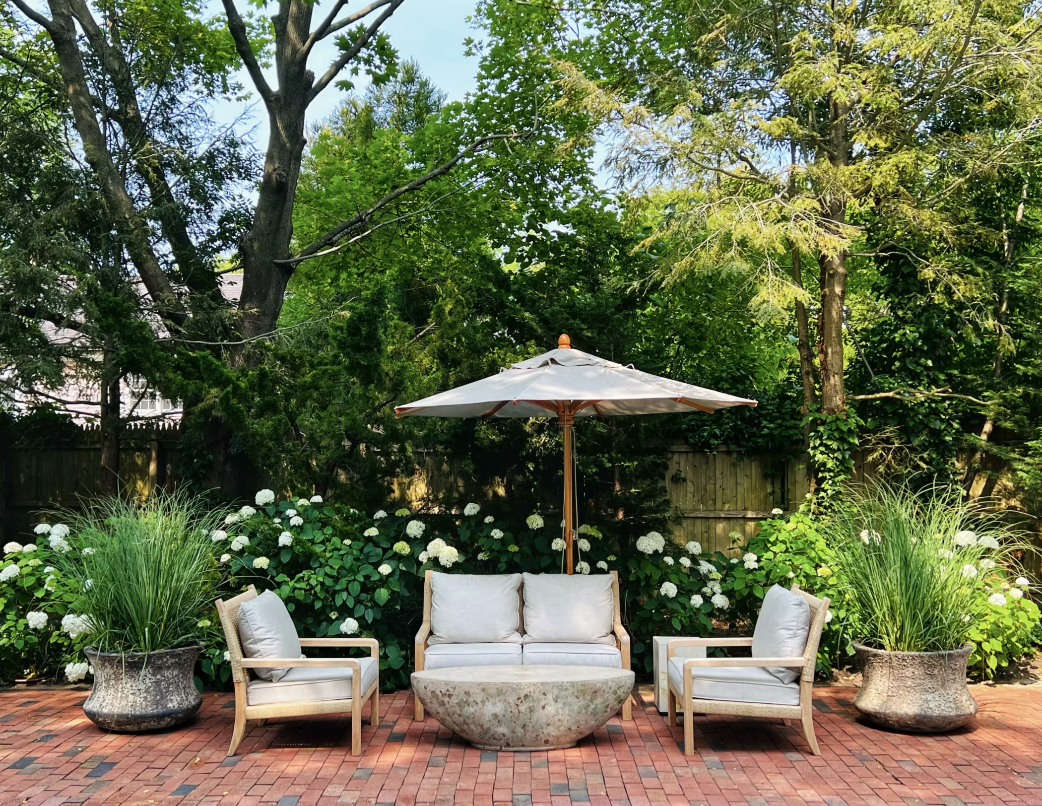 Outside Seating area on terracotta tile with colorful oval concrete coffee table and chairs and umbrella