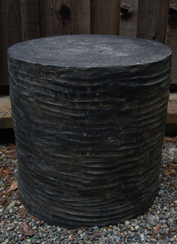 black concrete end table stool with sculptural lines horizontally going across sides