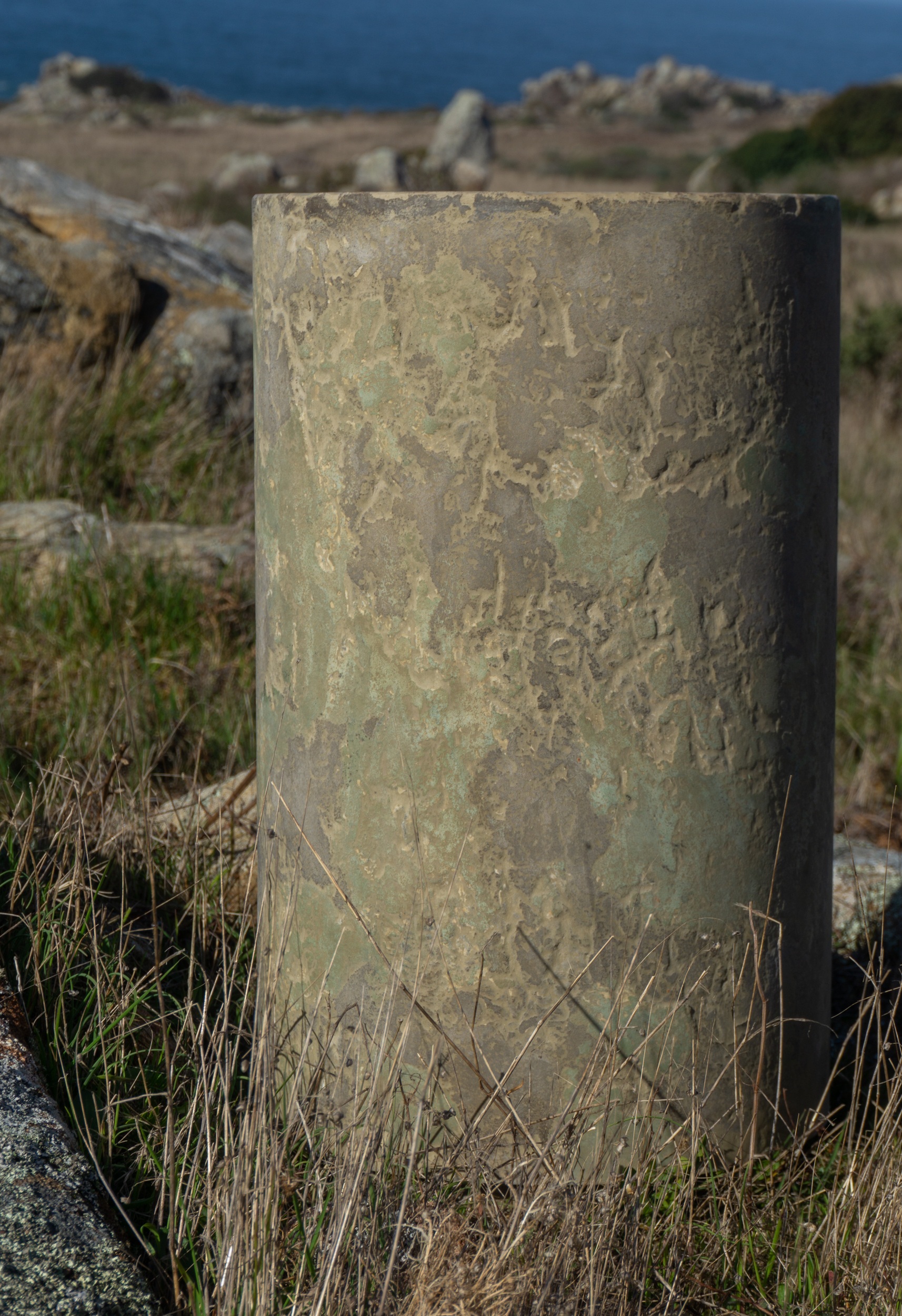 Closeup of Small concrete stool in green and brown at gerstle cove bluffs