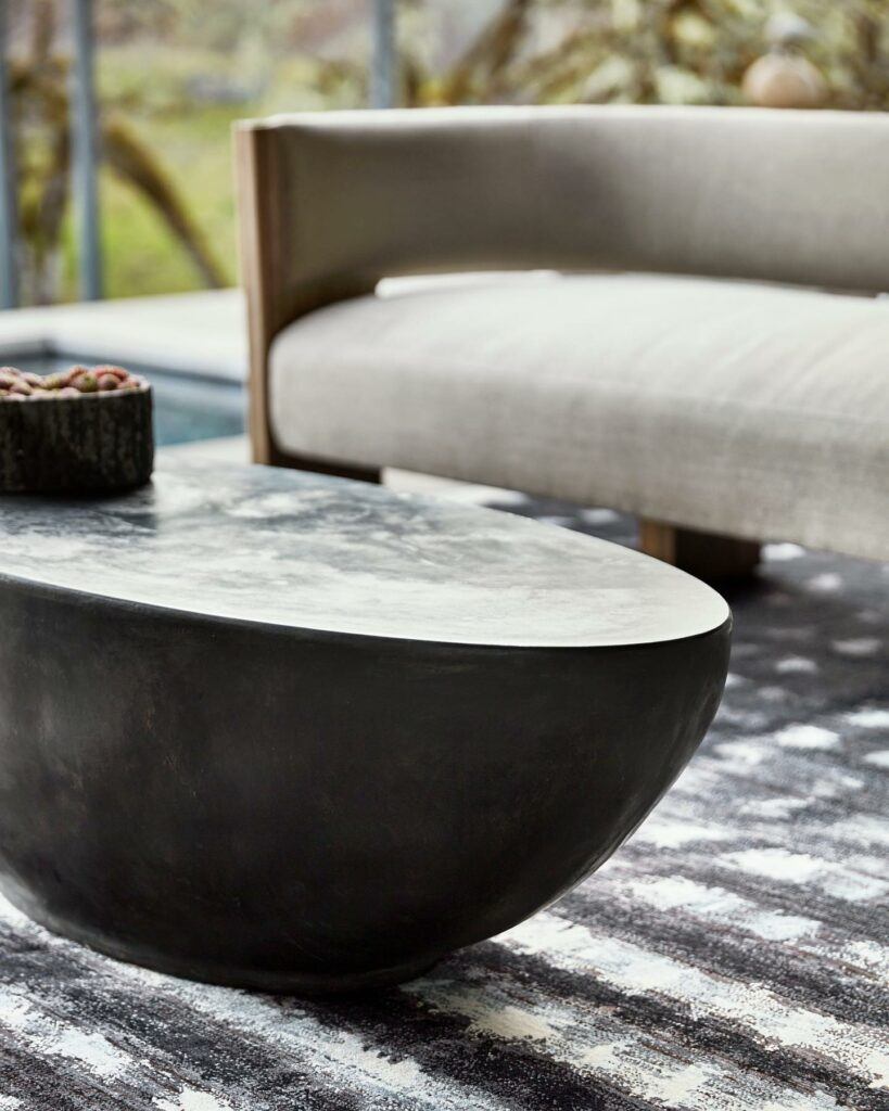 closeup of dark brown oval rustic coffee table with botanical design on top